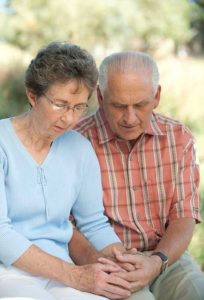 elderly couple praying together